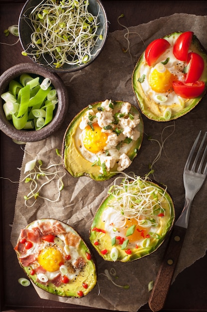 Uova al forno in avocado con pomodoro formaggio pancetta e germogli di erba medica