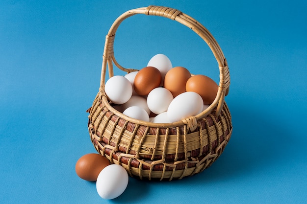 Eggs in a basket over blue background.