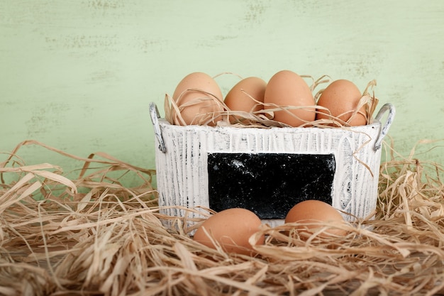 Foto uova in un cesto e nel fieno