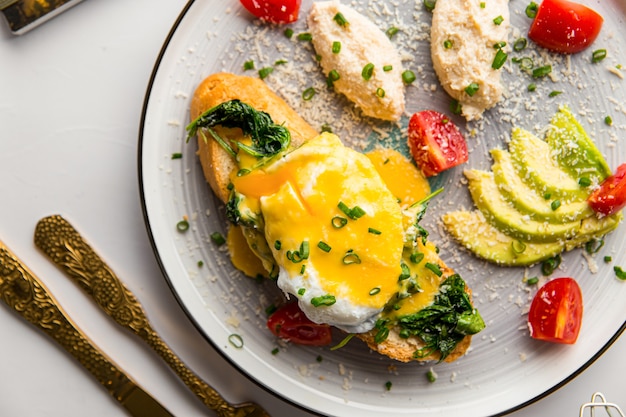 Eggs benedict with chicken pate and avocado