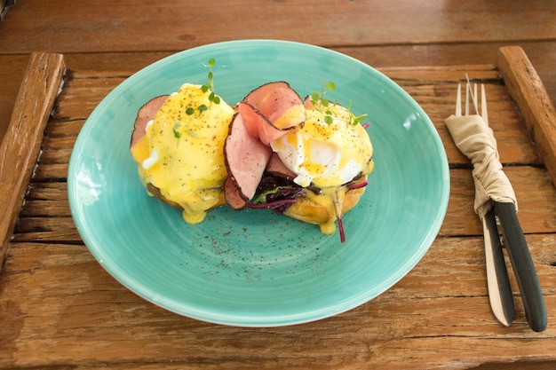 Eggs Benedict on wooden plate background