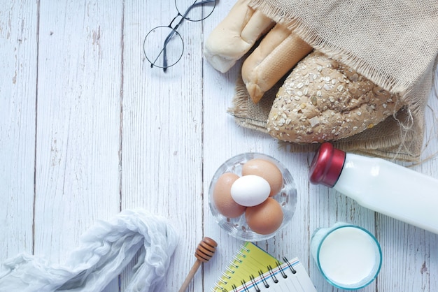 Uova in una ciotola pane integrale e latte sul tavolo