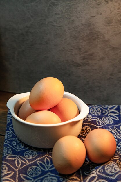 The eggs in bowl on wood table for food content.