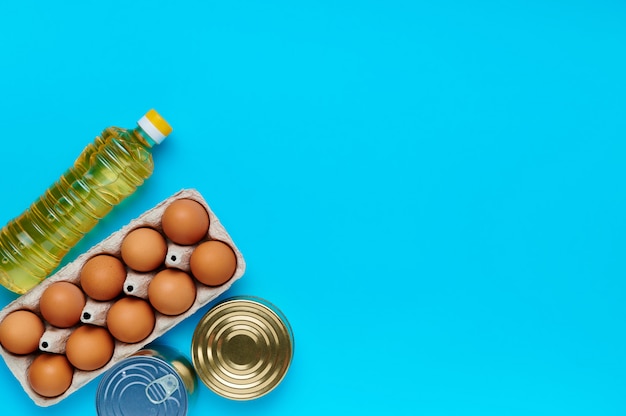 Eggs, canned food, oil on blue