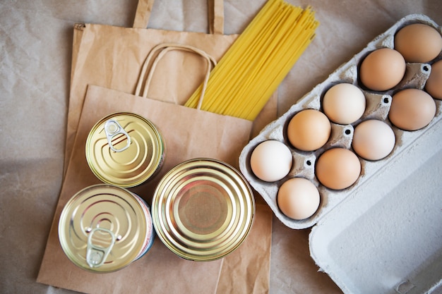 Eggs over canned food and pasta in environmentally friendly craft packages