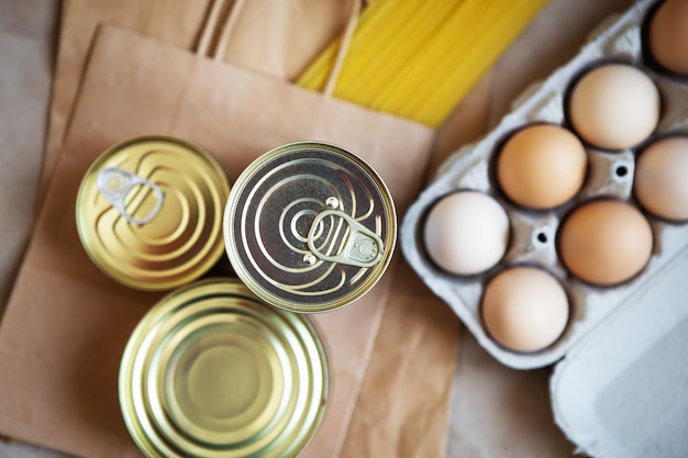 Eggs over canned food and pasta in environmentally friendly craft packages