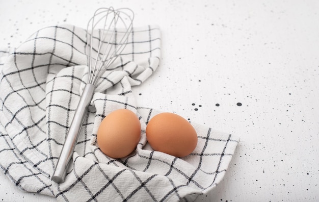 Eggs a corolla and a dishcloth on a light background