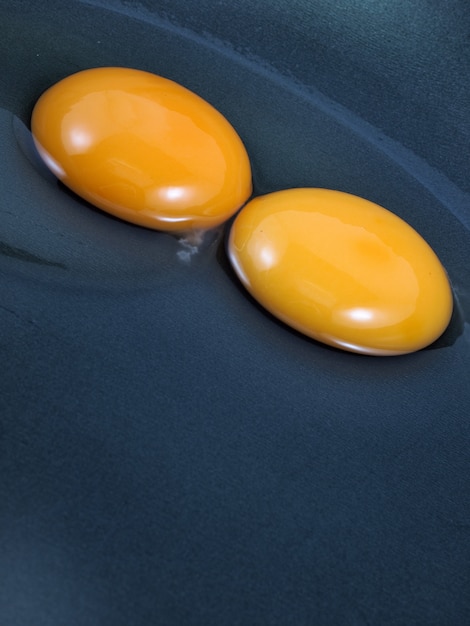 Eggs cracked on a black pan