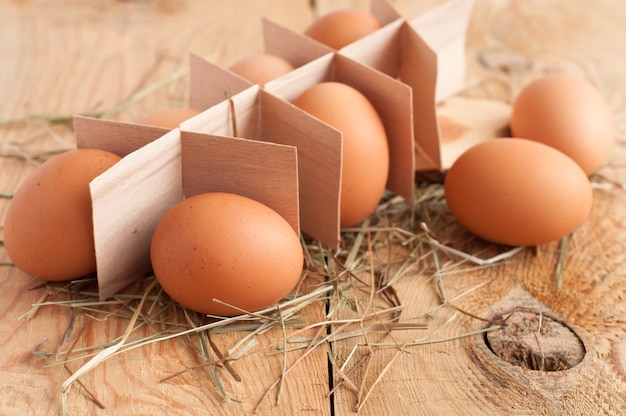 Eggs and hay on wooden background