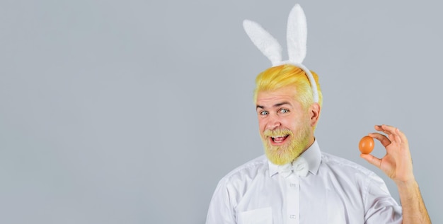 Eggs hunt smiling man in rabbit ears with easter egg bearded man in bunny ears easter rabbit man