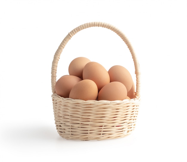 Фото Яйца в плетеной корзине на белом фоне