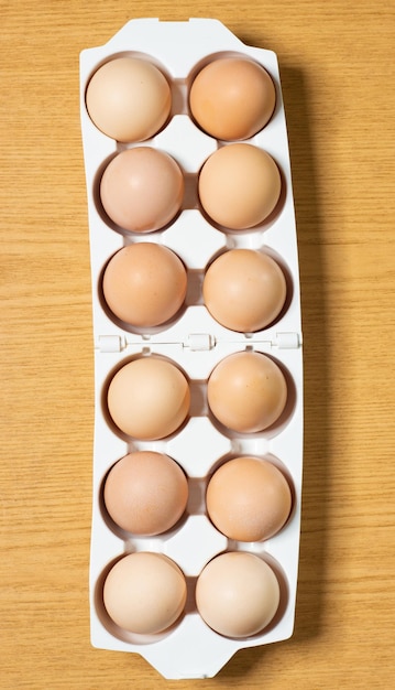 プラスチック製のトレイの木製の背景に置かれた卵
