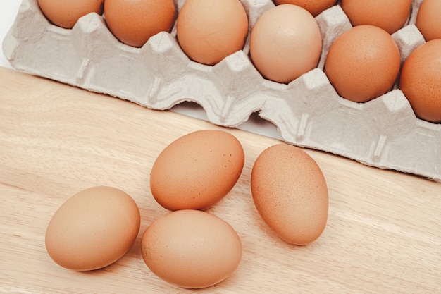 The eggs on the paper tray and wooden chopping board