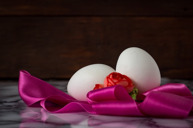 Eggs, Pink Tape, Flowers on the Wooden surface. Easter concept