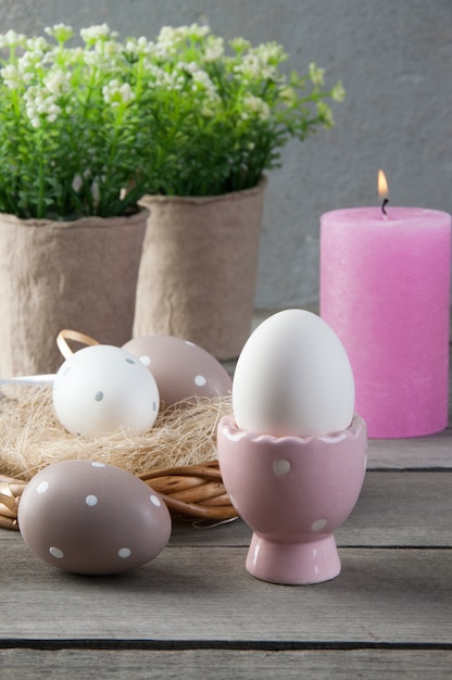 Eggs and rose aroma candle on old wooden background