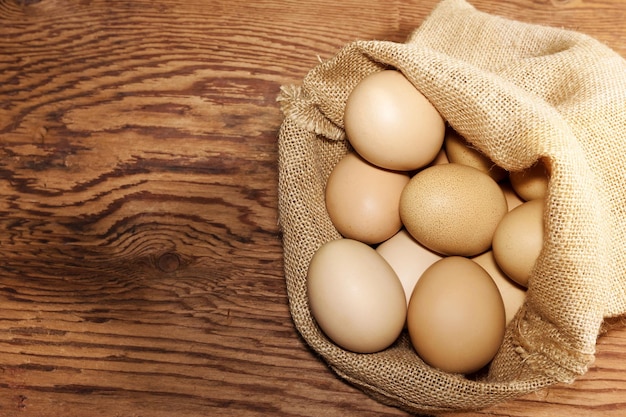 eggs in sackcloth bag on wooden table