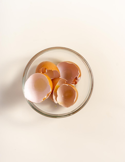 Eggs shell in glass bowl isolated on a white background Flat lay Top view