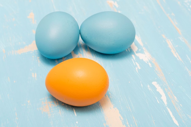 오래된 나무 배경에 파란색과 주황색으로 부활절 휴가를 상징하는 계란