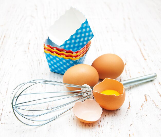 Eggs, whisk and cupcake liners