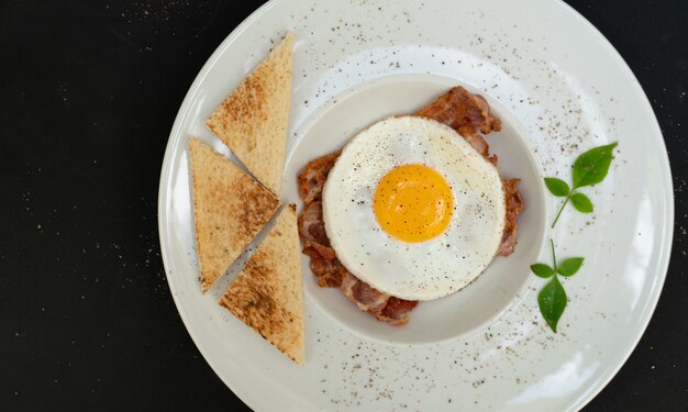 Uova con pancetta e toast sul piatto