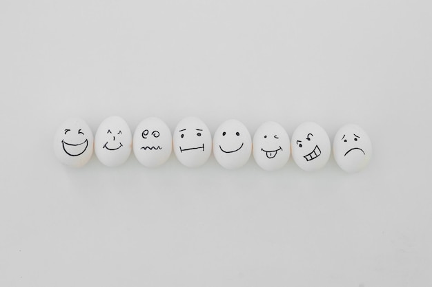 Eggs with funny faces on white background