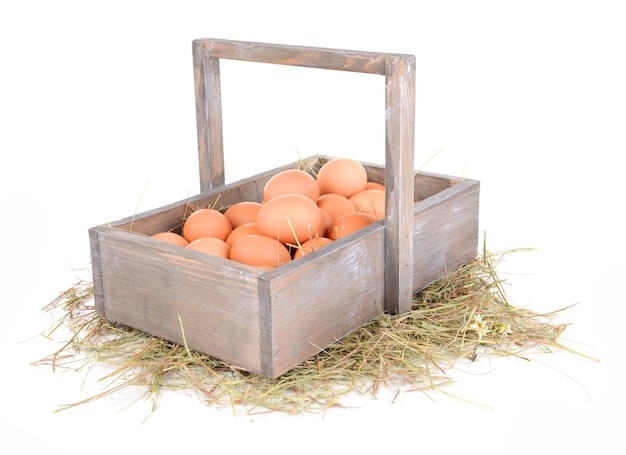 Photo eggs in wooden basket isolated on white
