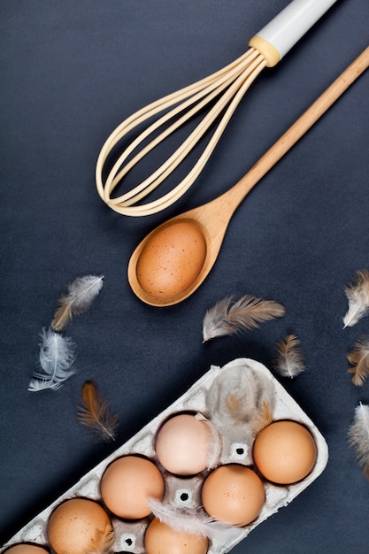 Eggs, wooden spoon, whisker and feathers.