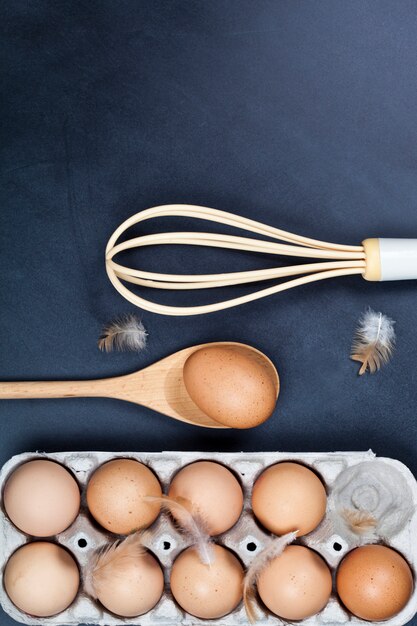 Eggs, wooden spoon, whisker and feathers. 