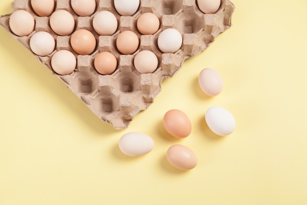 Eggs on yellow background food concept