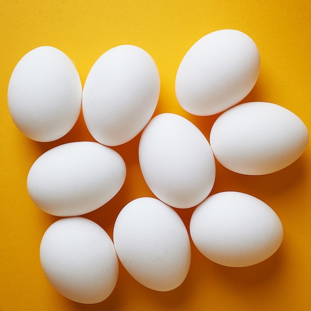 Eggs on a yellow background Smooth beautiful eggs space for textMinimalism The view from the top