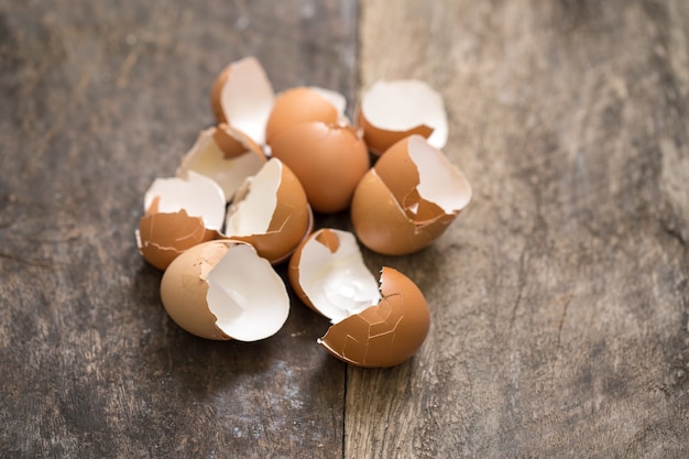 Eggshells on textured wooden background