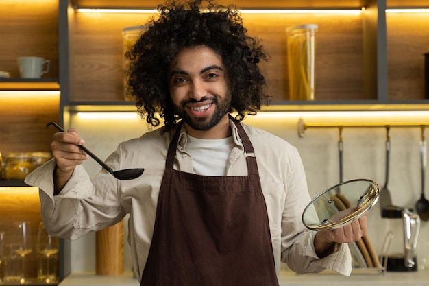 Egyptian man chef tastes cooked soup from ladle in kitchen