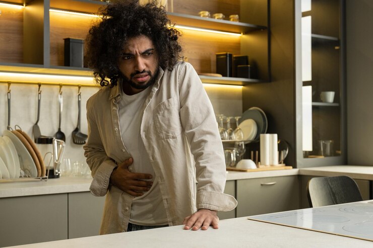 Photo egyptian man suffers from sudden pain in stomach in kitchen