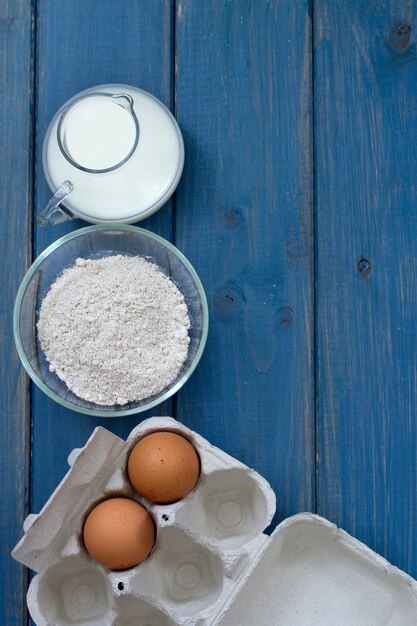 Ei en melk op blauwe houten oppervlak