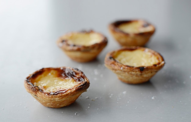 Ei taart traditioneel Portugees dessert pastel de nata pasteis op een plaat grijze stenen achtergrond