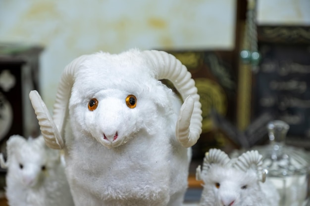 Photo eid adha sheeps dolls in white color and quran in the background
