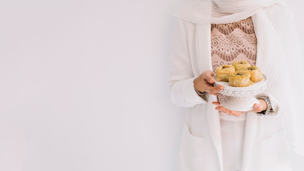 Foto concetto di eid con la donna che tiene pasticceria araba