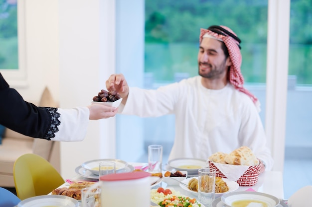 Eid Mubarak moslimfamilie die een Iftar-diner heeft en data eet om het feest te breken. Thuis traditioneel eten eten tijdens de Ramadan-feestmaand. Het islamitische halal eten en drinken in de moderne westerse islam
