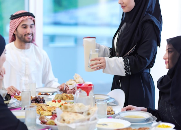 Eid Mubarak moslimfamilie met Iftar-diner drinkwater om het feest te breken. Thuis traditioneel eten eten tijdens de Ramadan-feestmaand. Het islamitische halal eten en drinken op de moderne westerse Isla