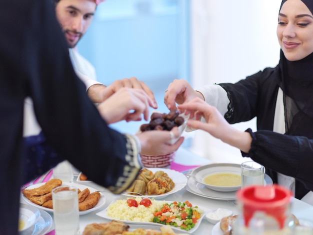 Eid Mubarak 무슬림 가족은 잔치를 중단하기 위해 Iftar 저녁 식사 날짜를 먹고 있습니다. 라마단 축제 기간 동안 집에서 전통 음식을 먹습니다. 현대 서구 이슬람에서 이슬람 할랄 먹고 마시기