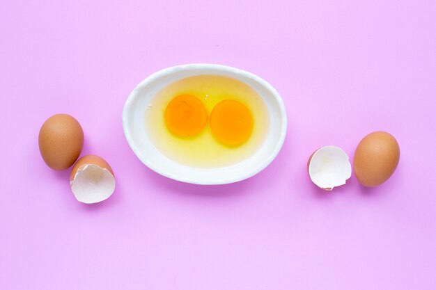 Eierdooier twee en wit in een kom op roze