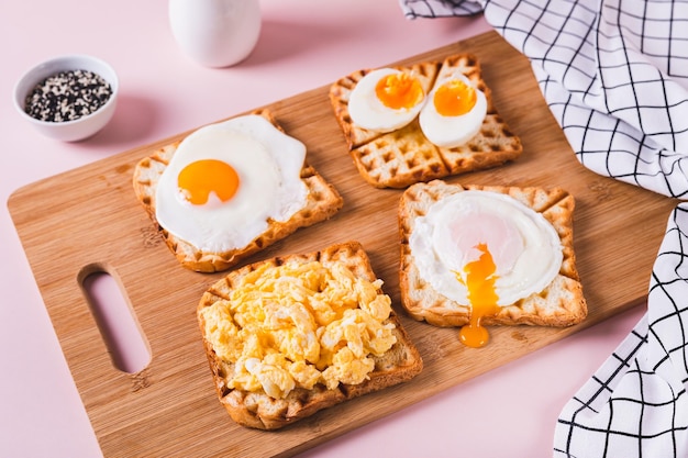 Eieren bereid naar verschillende recepten op toast op een houten plank