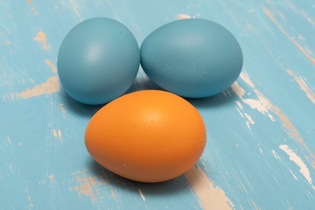 Eieren die de paasvakantie symboliseren in blauwe en oranje kleur op een achtergrond van oud hout