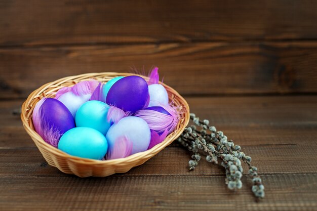 Eieren in een mand op een houten achtergrond. Concept Vrolijk Pasen.