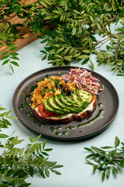 Eieren klauteren met avocado-sandwich en salade