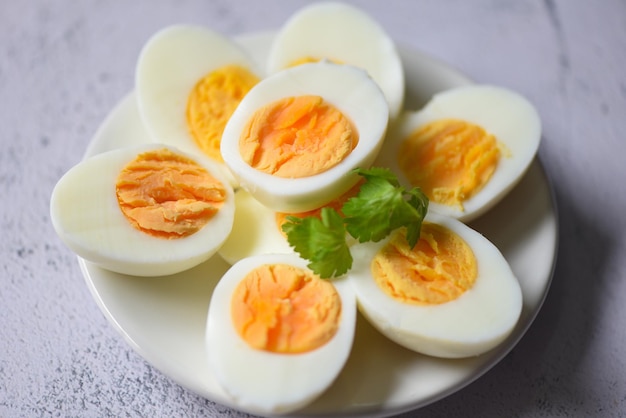 Eieren menu eten gekookte eieren in een witte plaat versierd met bladeren groene koriander, in tweeën gesneden eierdooiers voor het koken van gezond eten eieren ontbijt