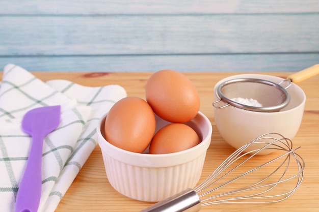 Eieren zwaaien en keukengerei op houten tafel voor het concept van cooking