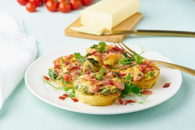 Eiermuffin gebakken met spek en tomaten ketogene keto dieet pastel moderne close-up