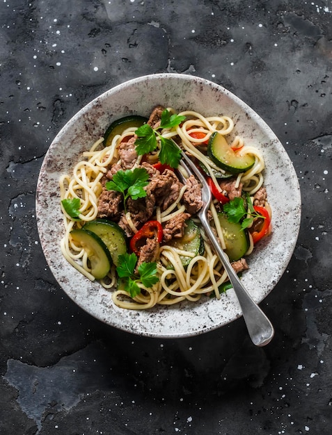 Eiernoedels met rundvlees paprika en courgette op een donkere achtergrond bovenaanzicht