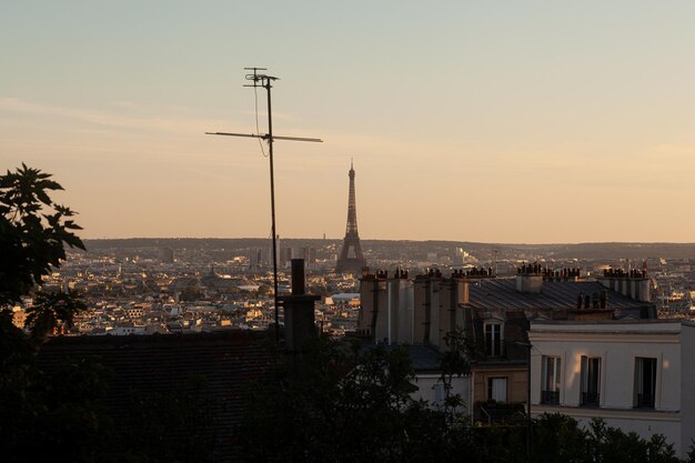 フランス・パリのモンマルトルの頂上から見たオレンジ色の空と日没時のエッフェル塔